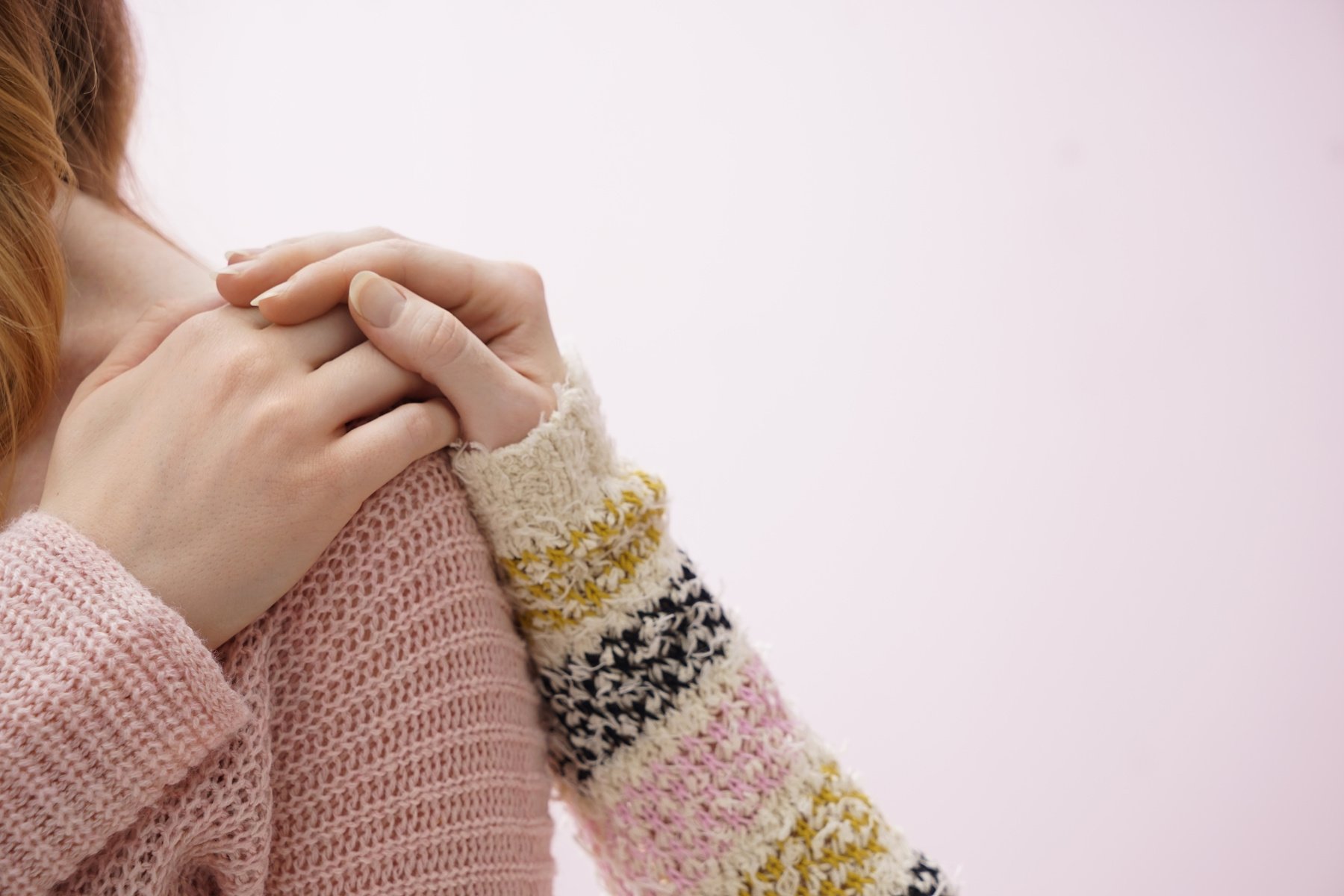 Young Woman Comforting Her Friend on Color Background