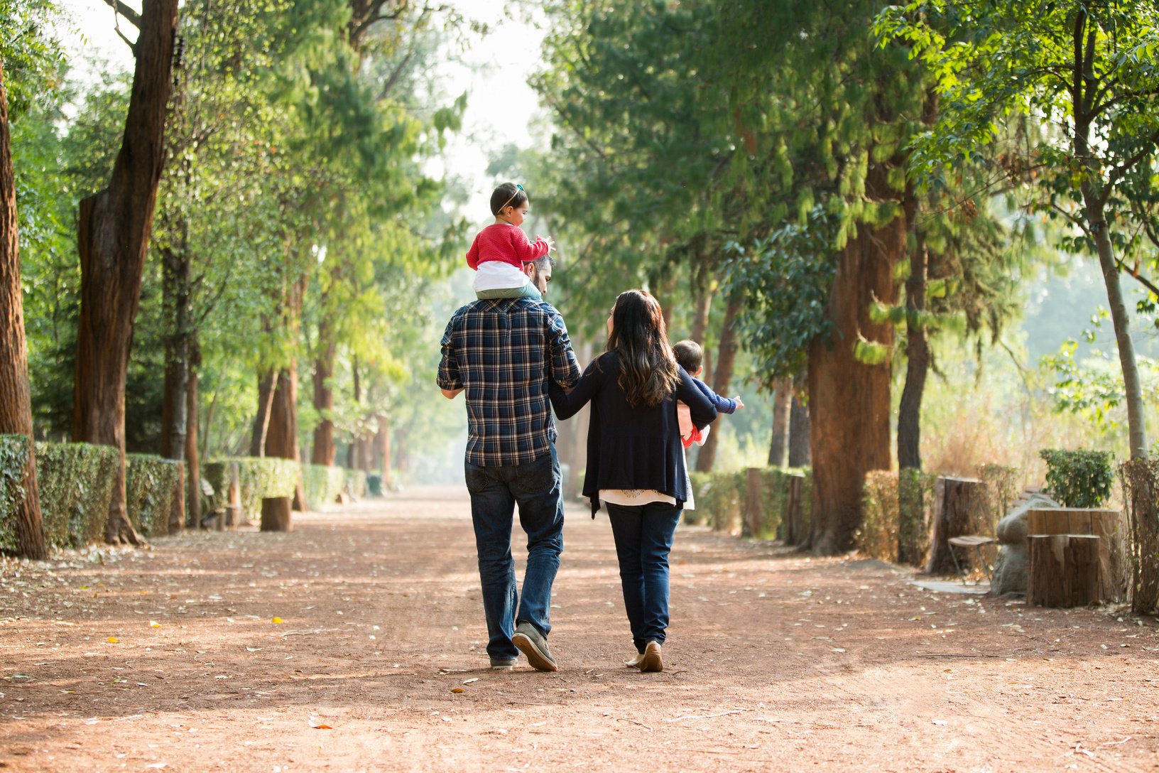 Back view of latin family walking on pathway